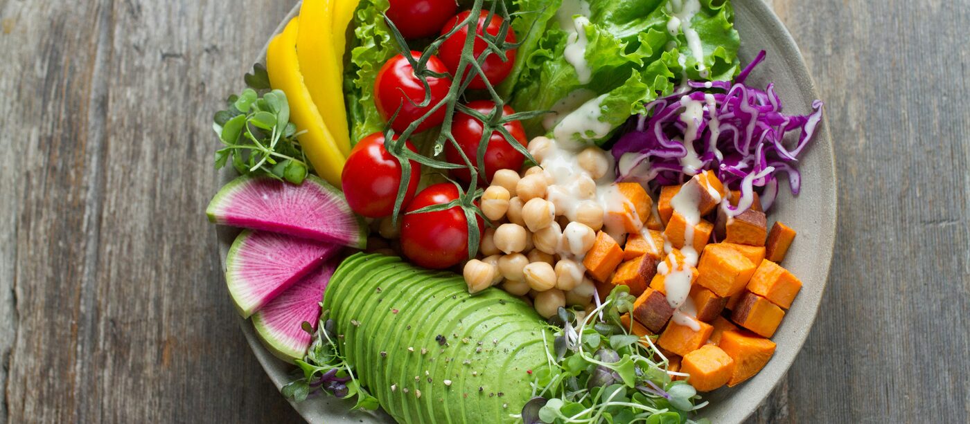 An overhead shot of a bowl of vegetables, chickpeas and avocado